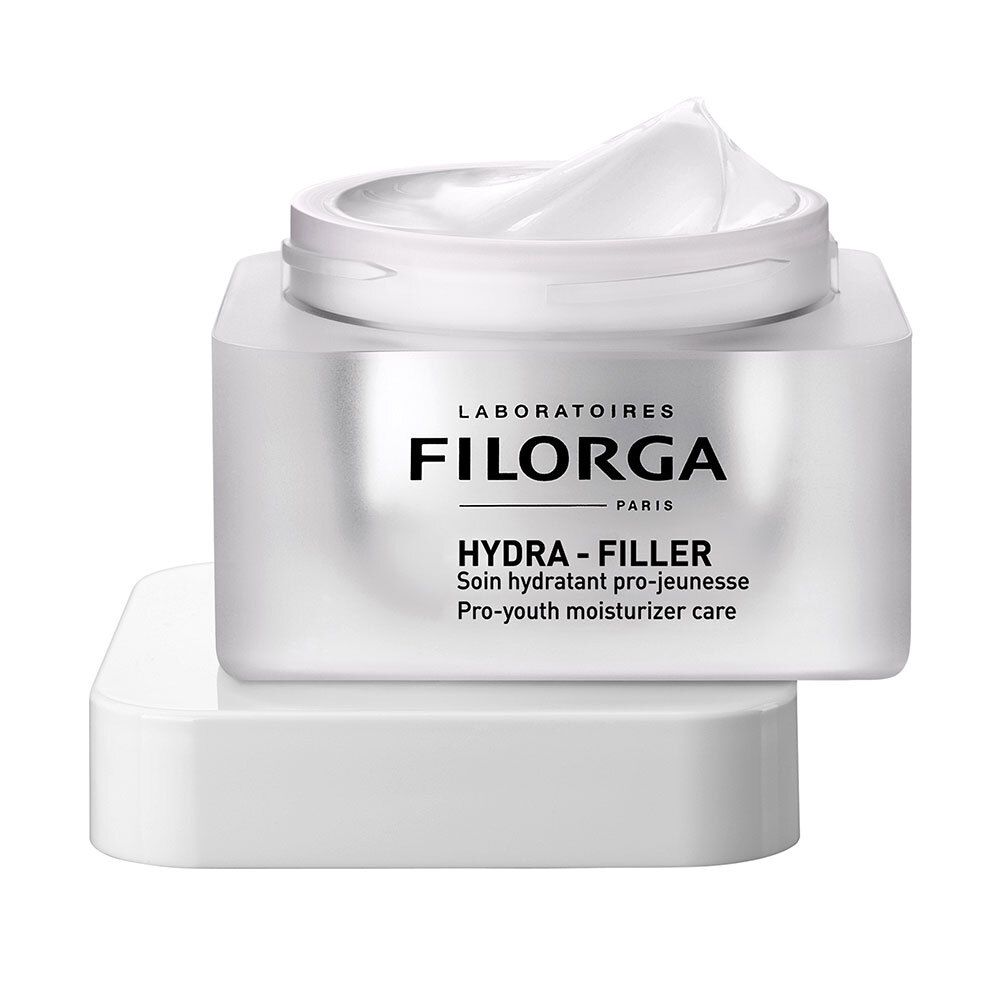 Weißer Tiegel mit Deckel, geöffnet. Creme sichtbar. Aufschrift FILORGA HYDRA-FILLER. Französische Produktbezeichnung und englische Übersetzung.
