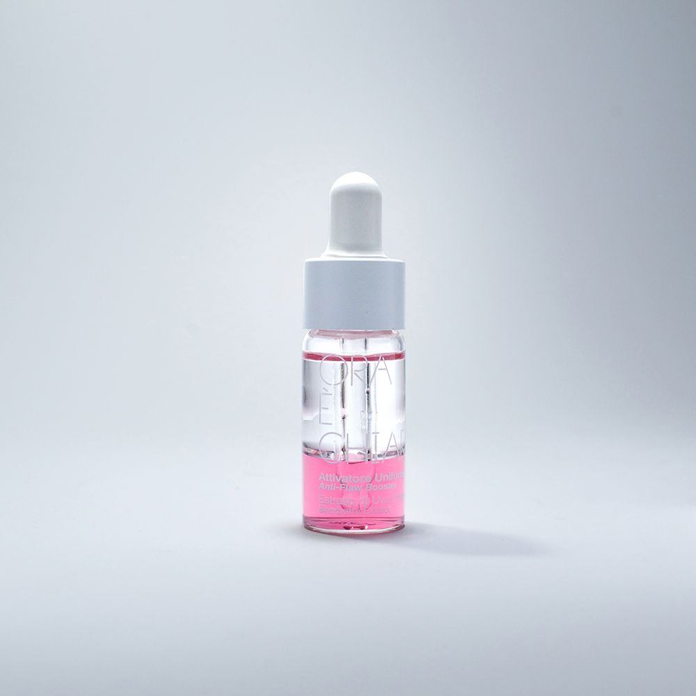Flacon en verre transparent avec pipette blanche. Le flacon contient un liquide rose.