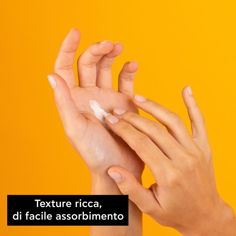 Mani che applicano la crema. Testo: Texture ricca, di facile assorbimento.
