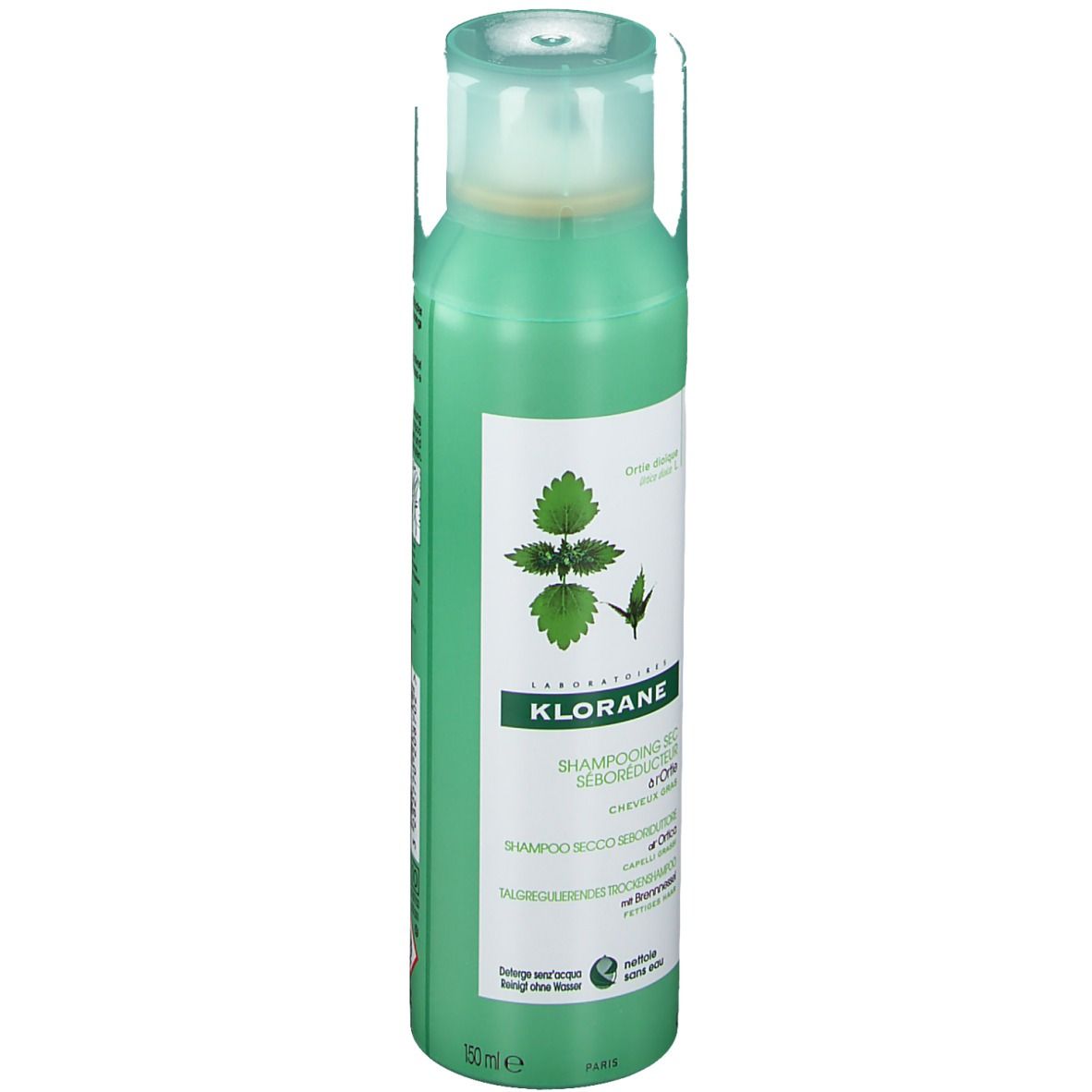 Flacon spray vert avec étiquette blanche. Shampooing sec KLORANE à l'ortie. Bouchon verdâtre.