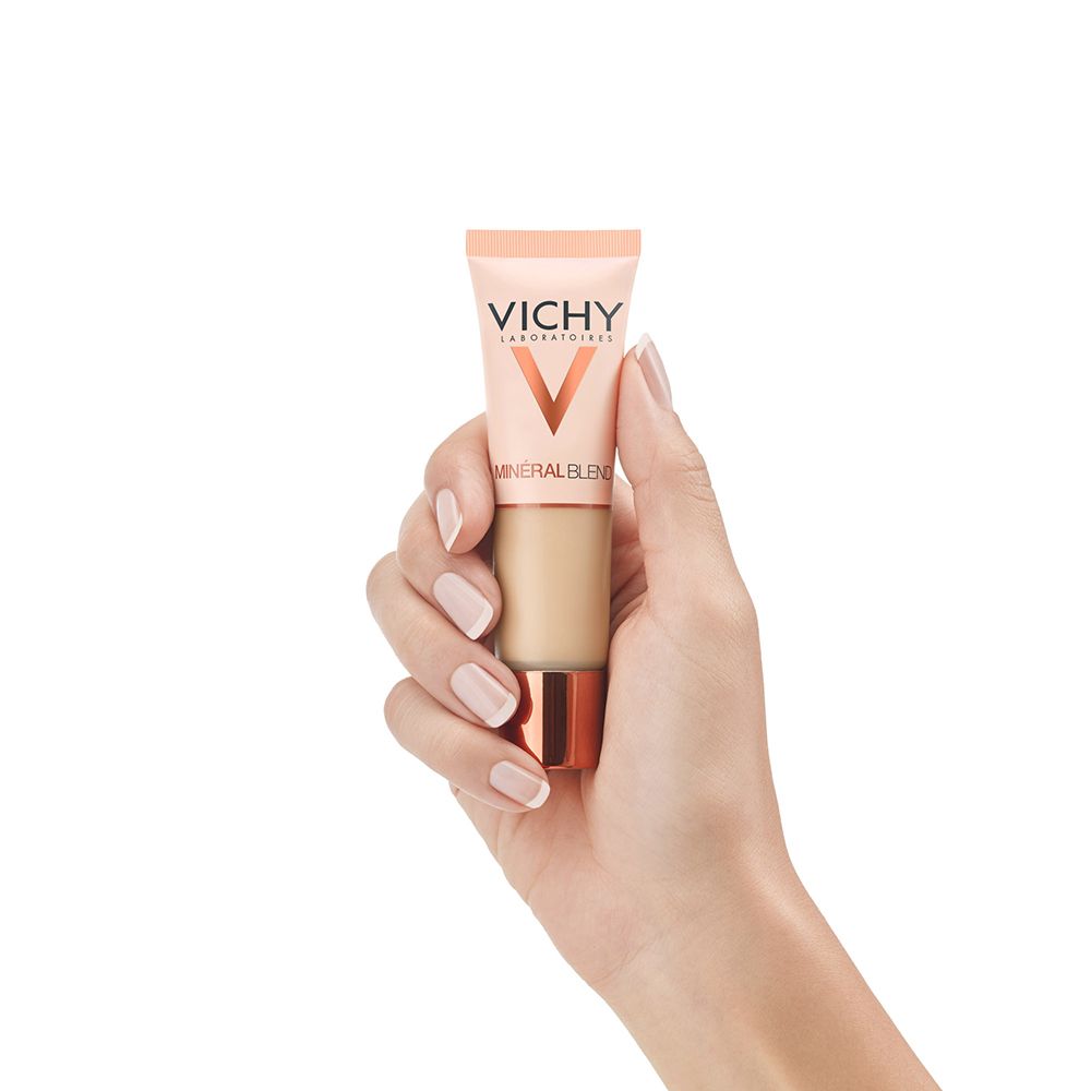 Mano che tiene un piccolo tubo. Sul tubo c'è scritto VICHY Mineralblend.