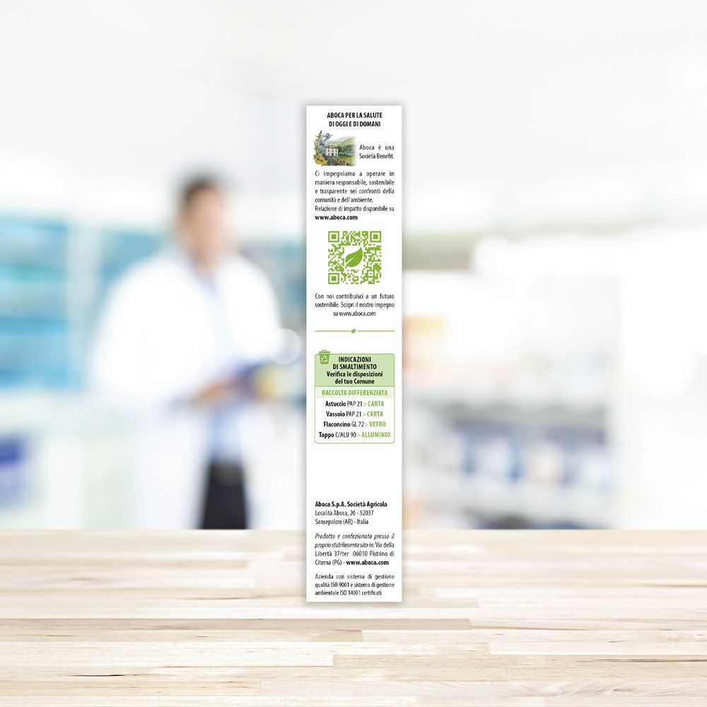 Schmale, grüne Produktverpackung. Natura Mix Mente-Logo. Aboca-Logo. Hintergrund: verschwommene Person.