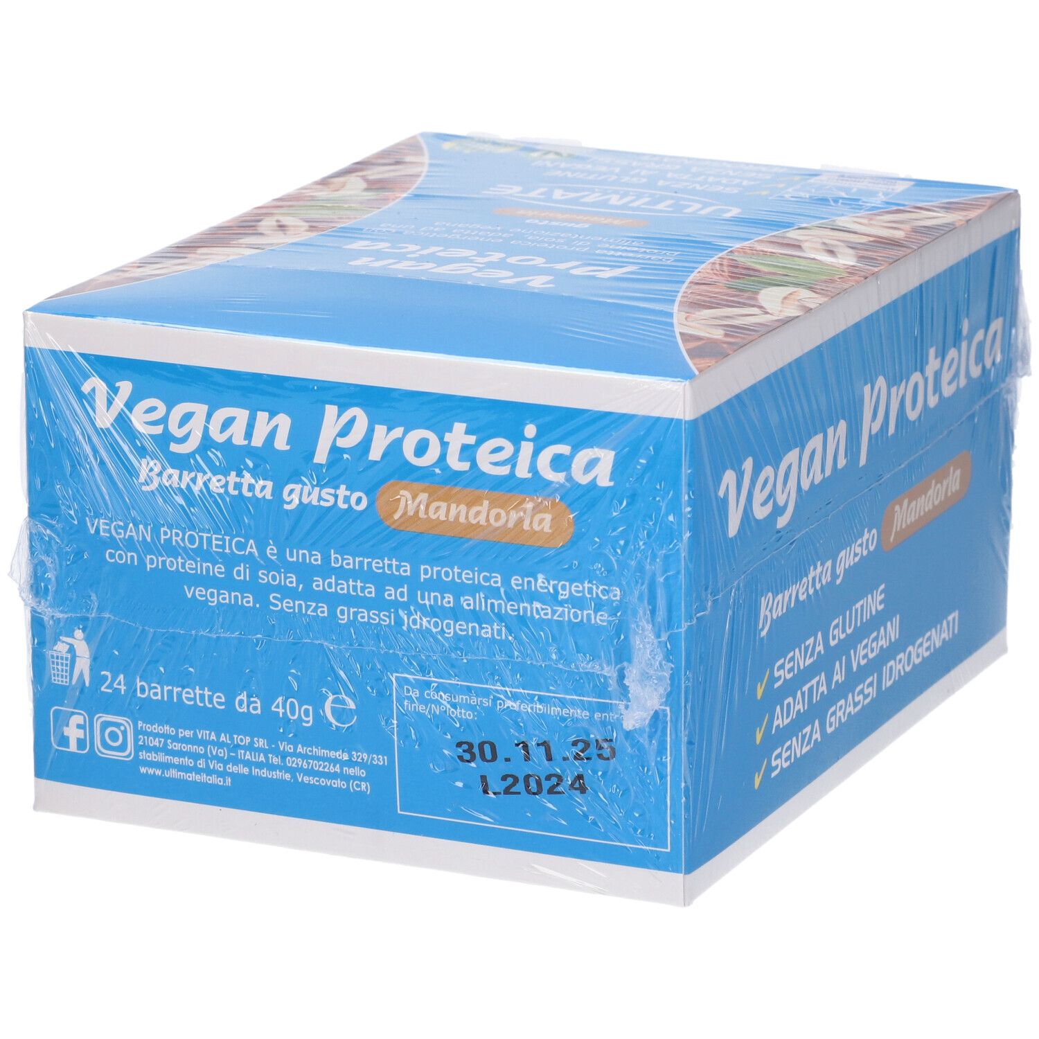 Scatola blu e bianca di barrette proteiche, avvolta in pellicola. Scritto: Vegan Proteica, Mandorla. 24 barrette da 40g. Data di scadenza.