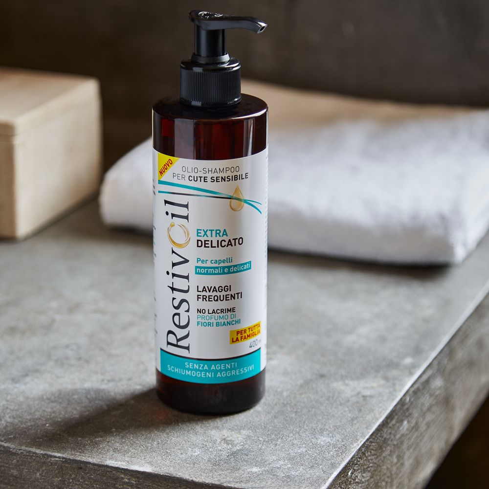 Flacone Restivoil su una superficie grigia. Dosatore nero. Testo: Extra Delicato. Per cute normale e delicata.