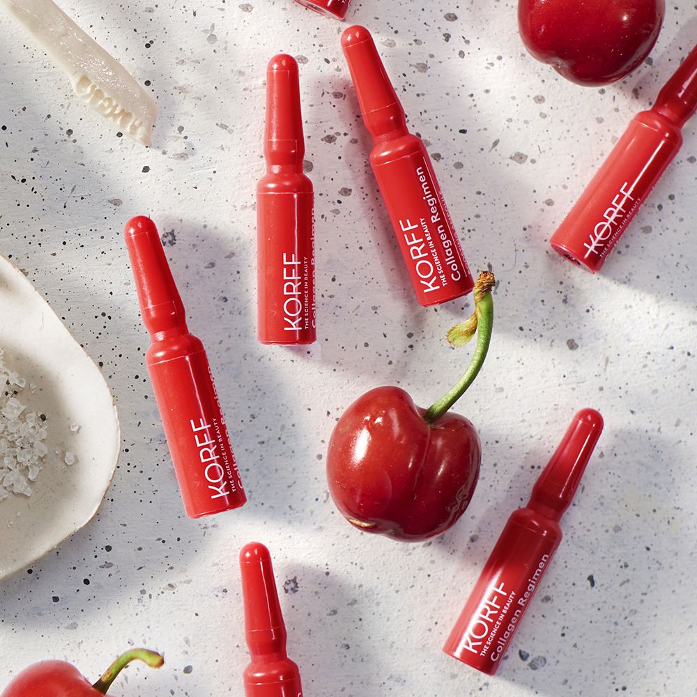 Mehrere rote Ampullen mit Produktnamen. Aufschrift: KORFF Collagen Regimen. Dekoration: Kirschen.