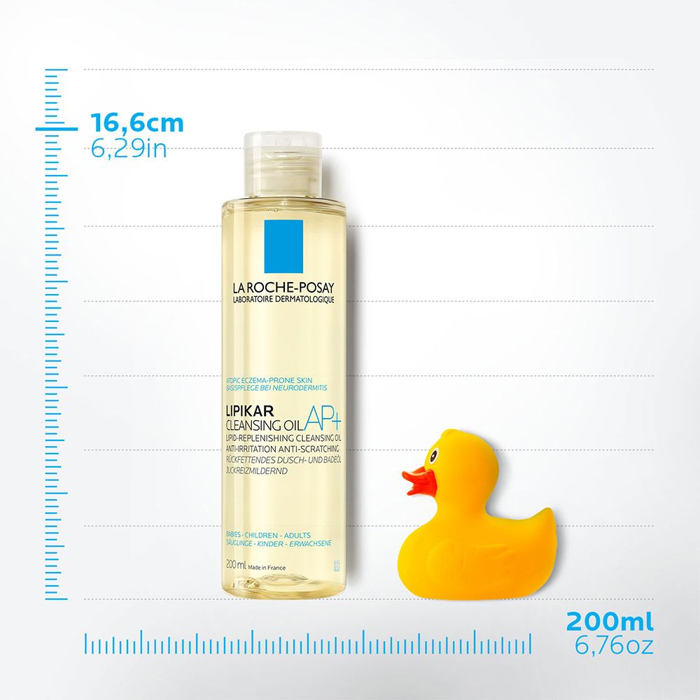 Flacone di olio detergente per il corpo, accanto a un'anatra di gomma gialla. Misure in cm e pollici.