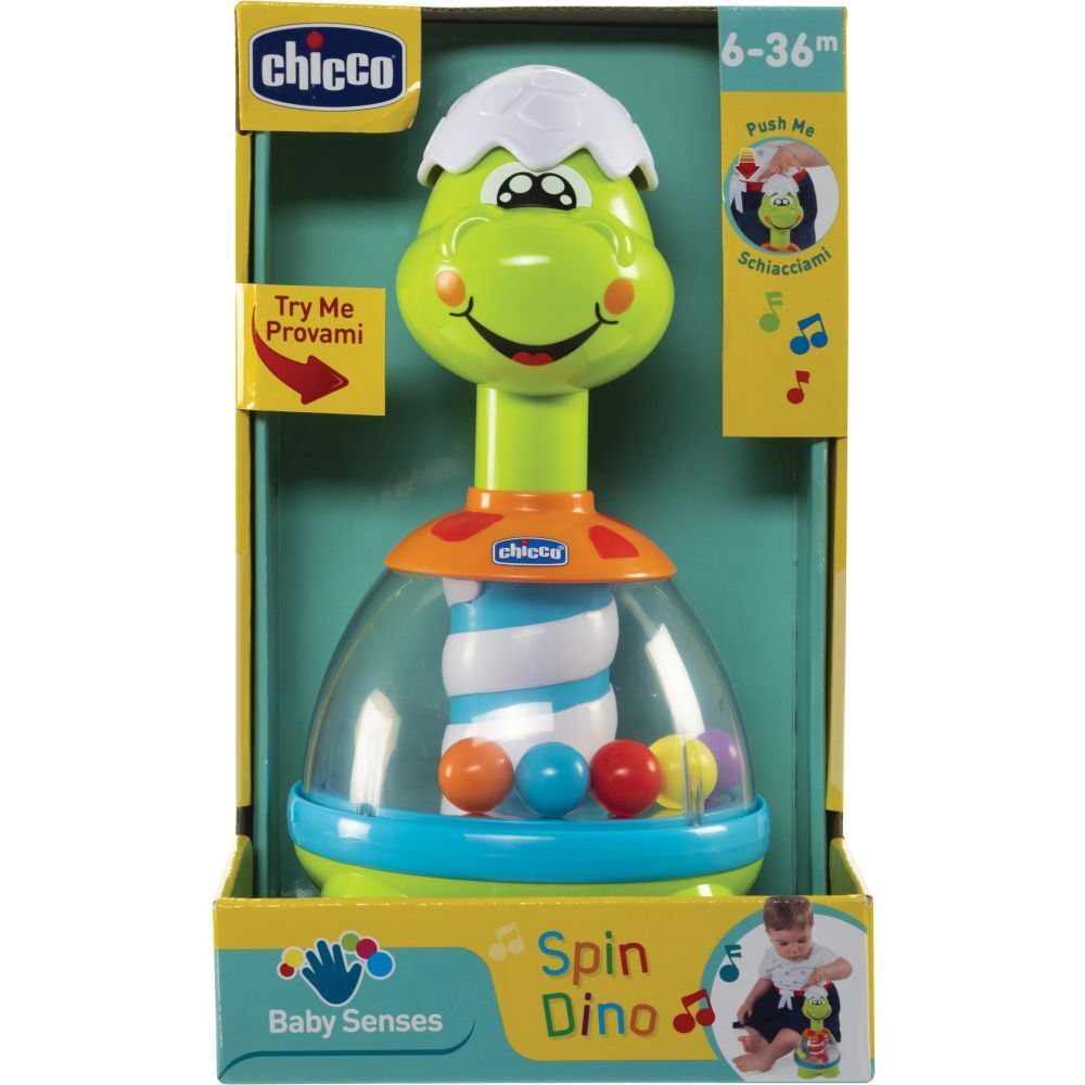 Spielzeug mit Dino-Design in Verpackung. Grüner Dino-Kopf, transparente Kugel mit bunten Kugeln. Altersempfehlung 6-36 Monate.