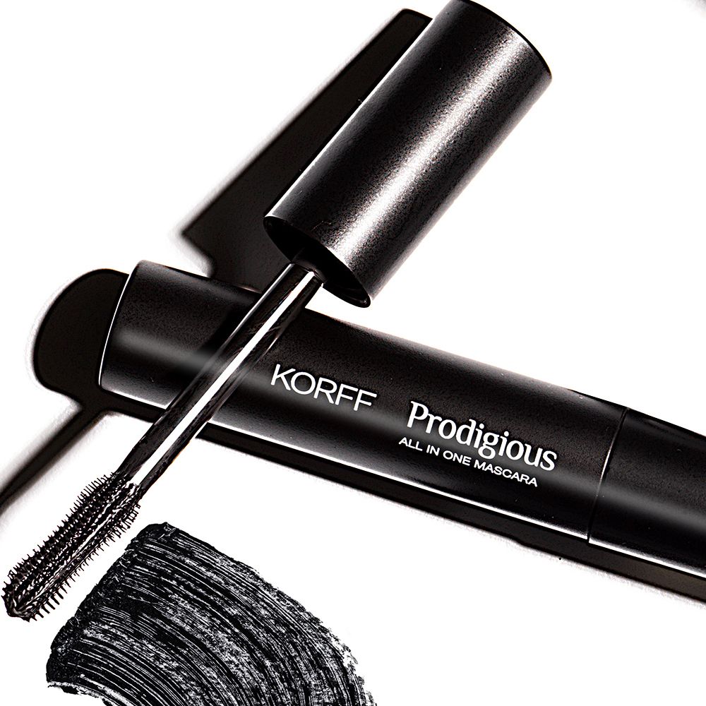 Mascara-Tube mit Bürste und schwarzem Mascara-Abdruck. KORFF Prodigious All in One Mascara.