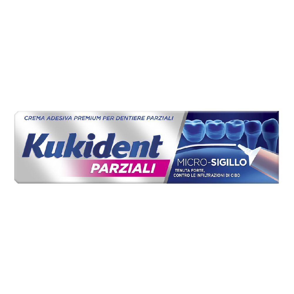 Tubo di crema adesiva per dentiere parziali. Marchio e testo in italiano. Colori bianco e blu.