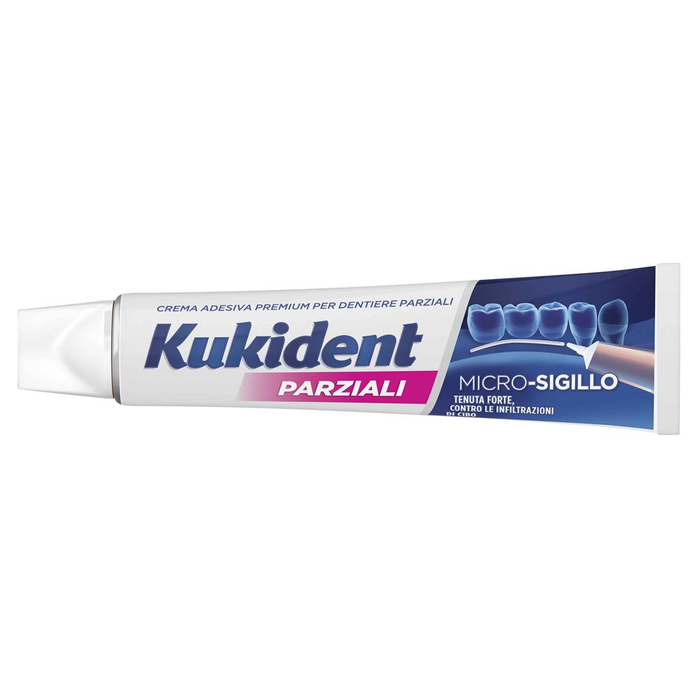 Tubo di crema adesiva per dentiere parziali. Marchio e testo in italiano. Colori bianco e blu.