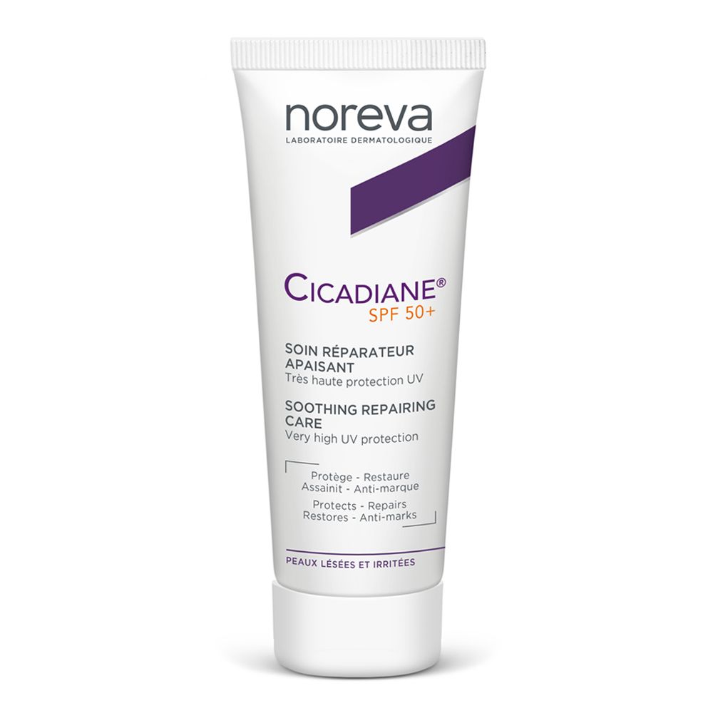 Tubo bianco con nome del prodotto e accento viola. Testo: Cicadiane SPF50+, trattamento riparatore lenitivo. Marca: Noreva.