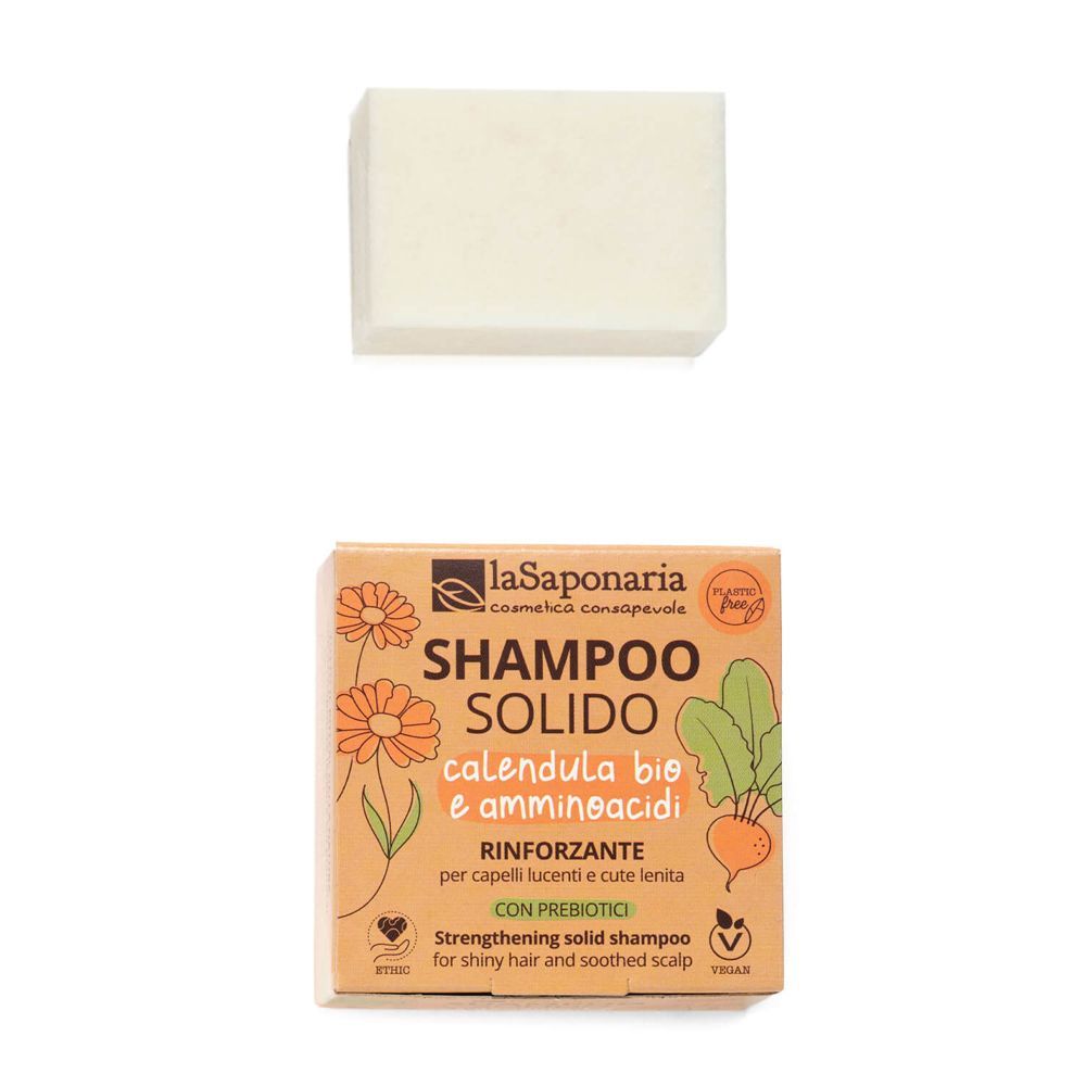 Shampoo solido quadrato, beige chiaro. Sopra, un pezzo di shampoo. Sotto, confezione con nome del prodotto e logo.