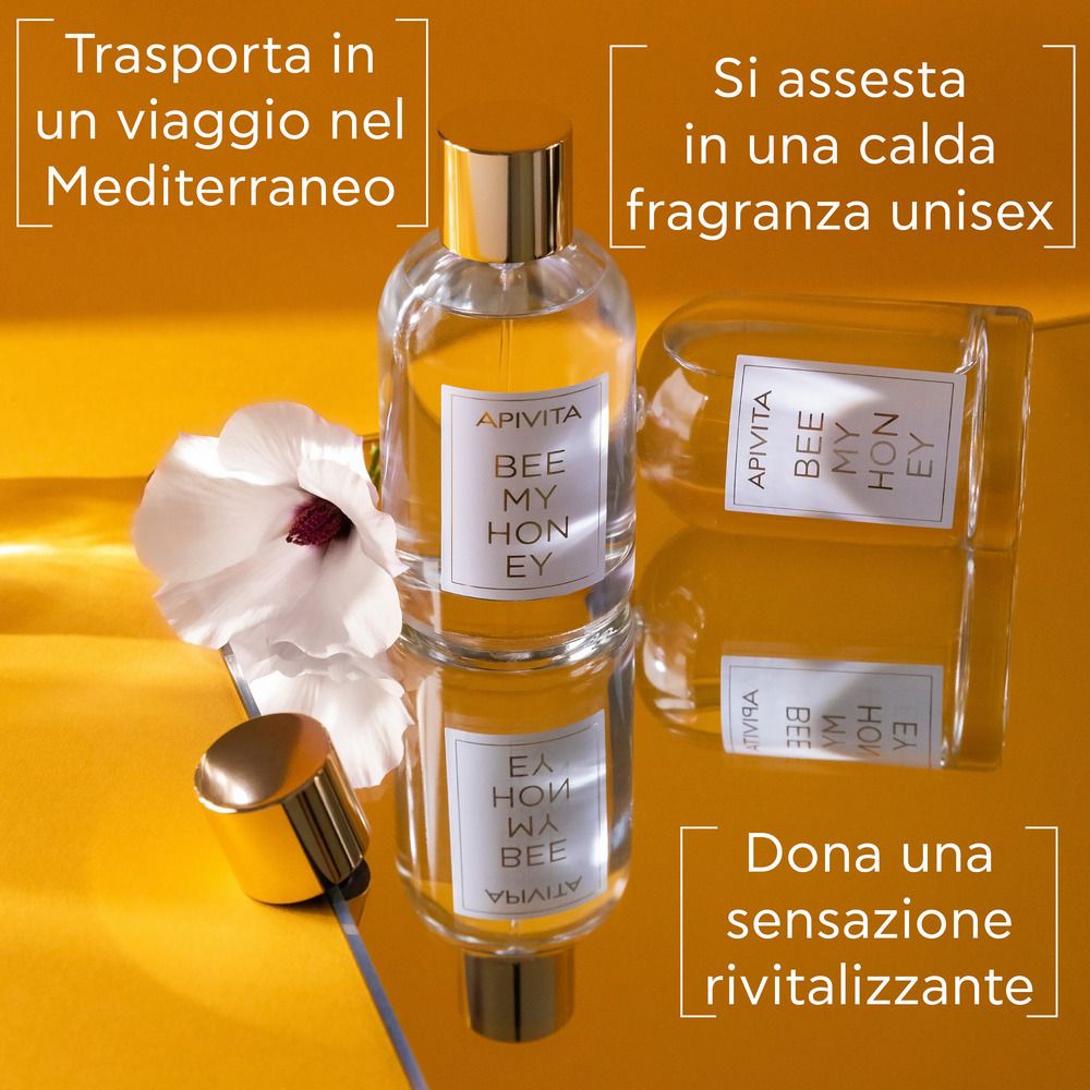 APIVITA Bee My Honey Eau de Toilette. Flaconi su superficie a specchio. Tappo dorato accanto. Nome del prodotto sull'etichetta.