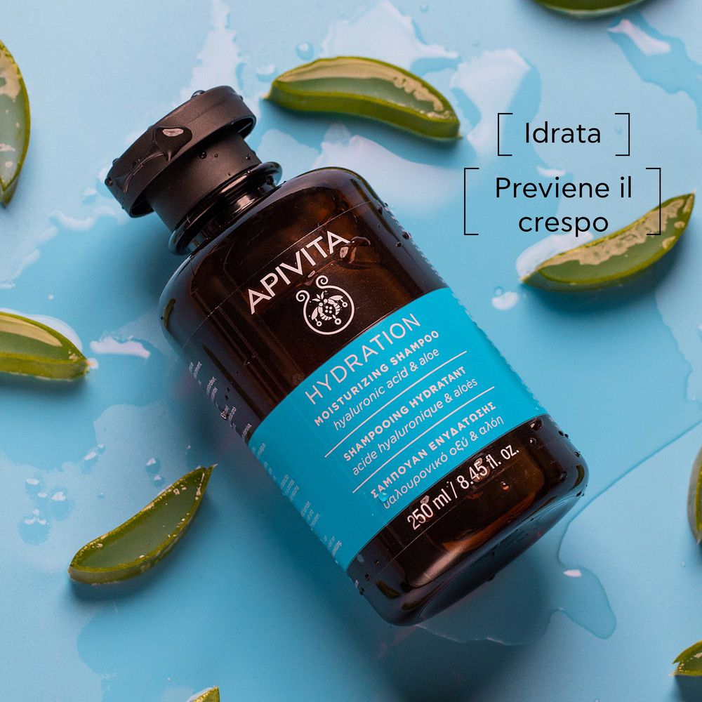 Flacone marrone con tappo nero, circondato da foglie di aloe vera. Nome del prodotto e ingredienti sull'etichetta.