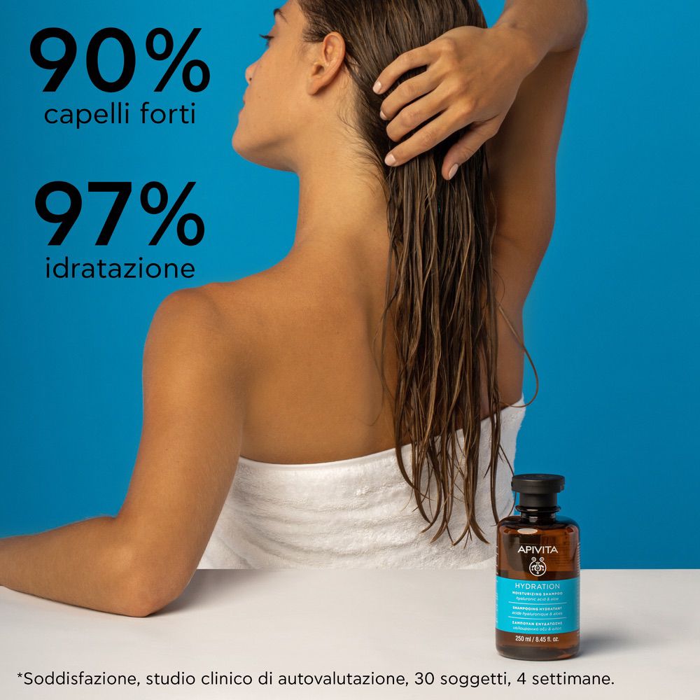 Donna con capelli bagnati. Flacone del prodotto sullo sfondo. Testo: 90% capelli forti, 97% idratazione.
