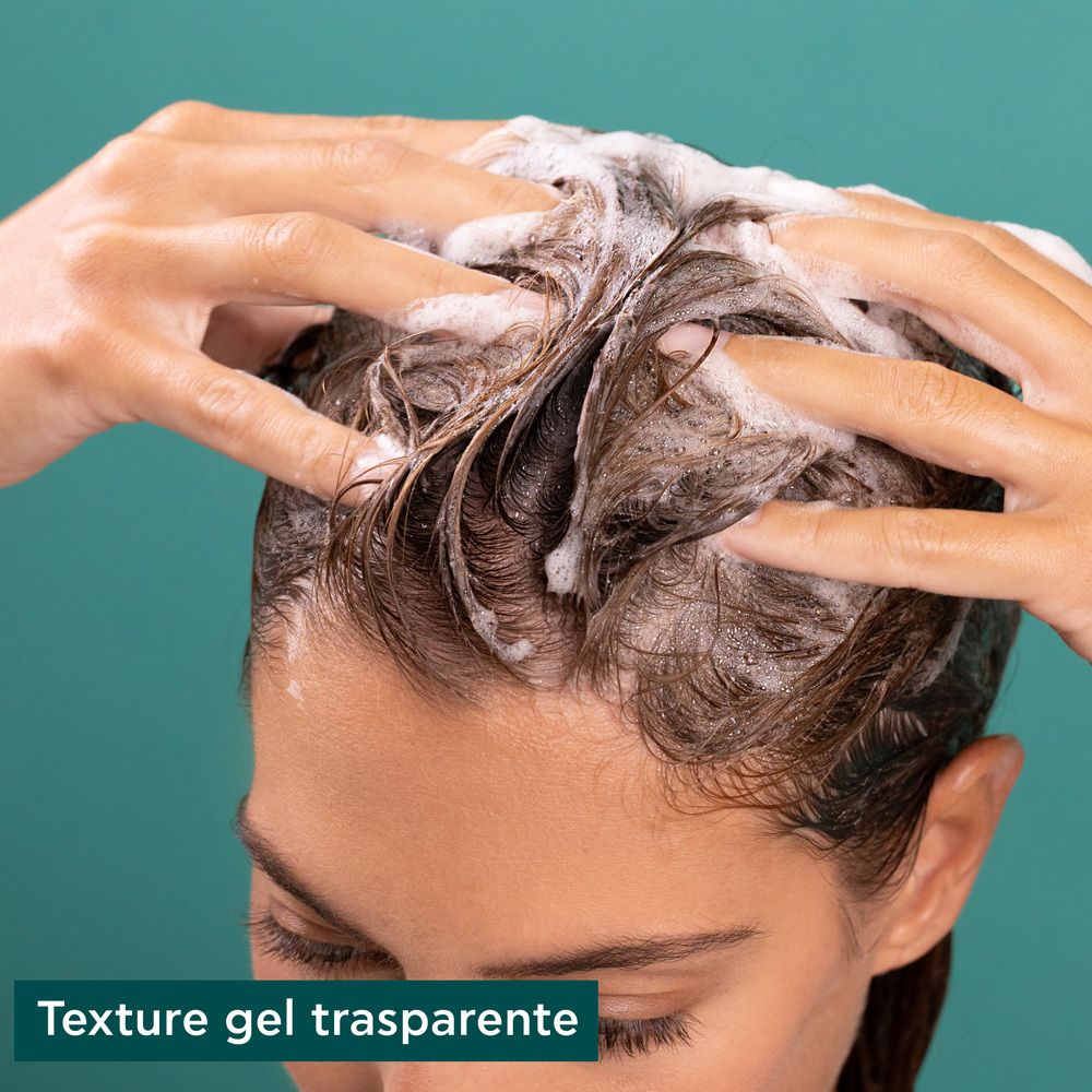 Mains lavant les cheveux avec mousse. Texte: Texture gel trasparente.