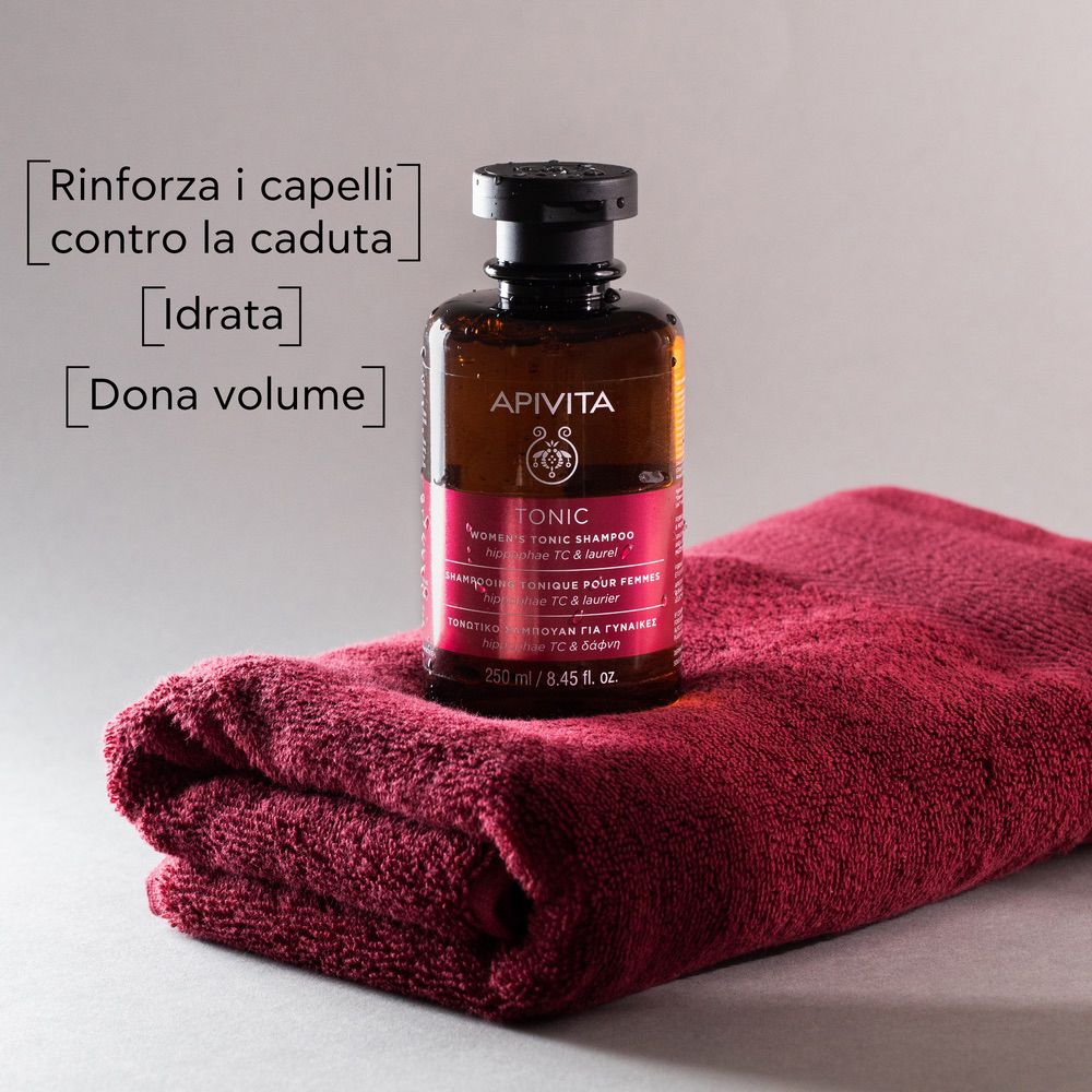 Flacone marrone su asciugamano rosso. Testo: Rinforza, idrata, dona volume.
