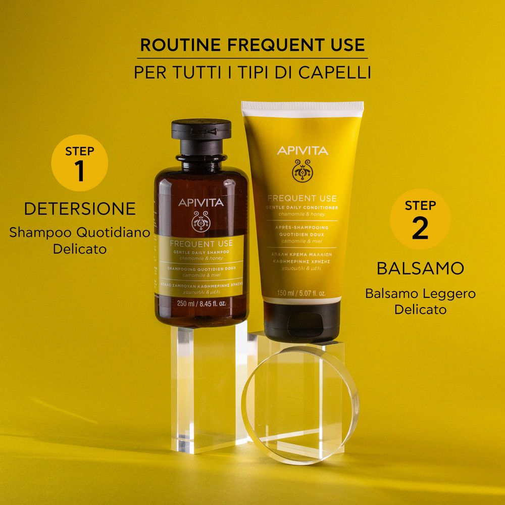 Due prodotti su piedistalli. Shampoo e balsamo. Marchio: APIVITA. Etichette gialle.