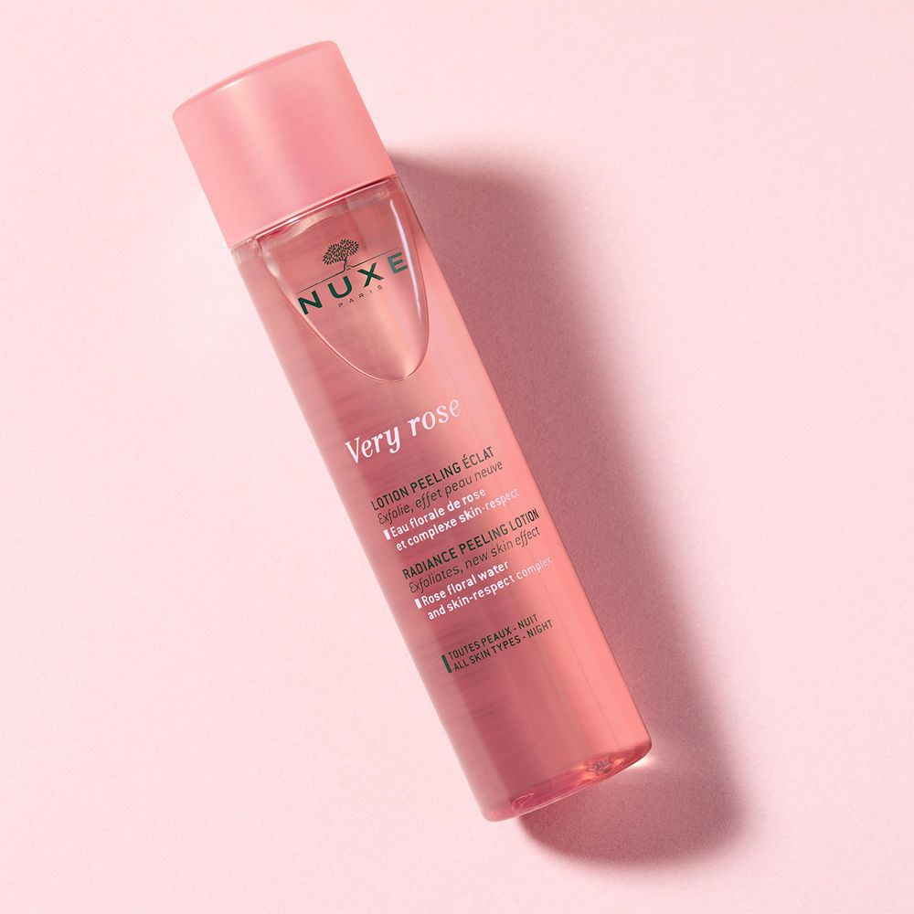 Flacone rosa inclinato con tappo rosa. Scritta: NUXE, Very Rose, Lotion peeling éclat.