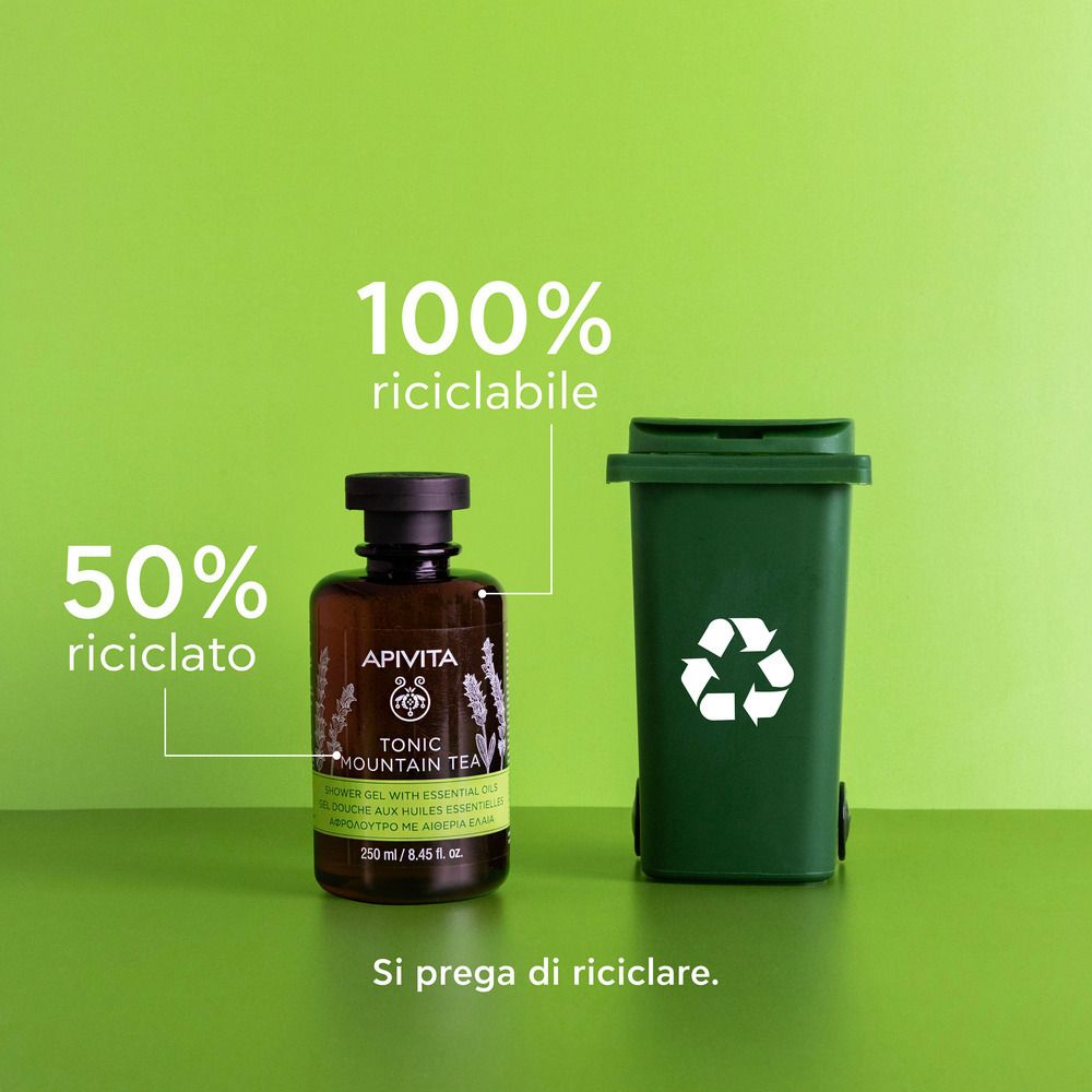 Flacone di gel doccia APIVITA TONIC MOUNTAIN TEA accanto a un bidone verde. Testo: 100% riciclabile, 50% riciclato.