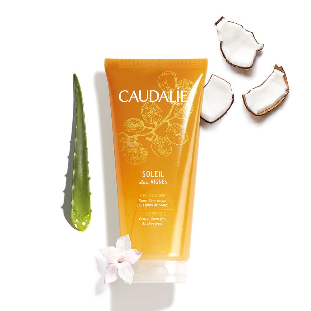 Gel-Dusche neben Aloe Vera, Kokosnuss-Stücken und Blüte. Aufschrift CAUDALÍE, SOLEIL des VIGNES.