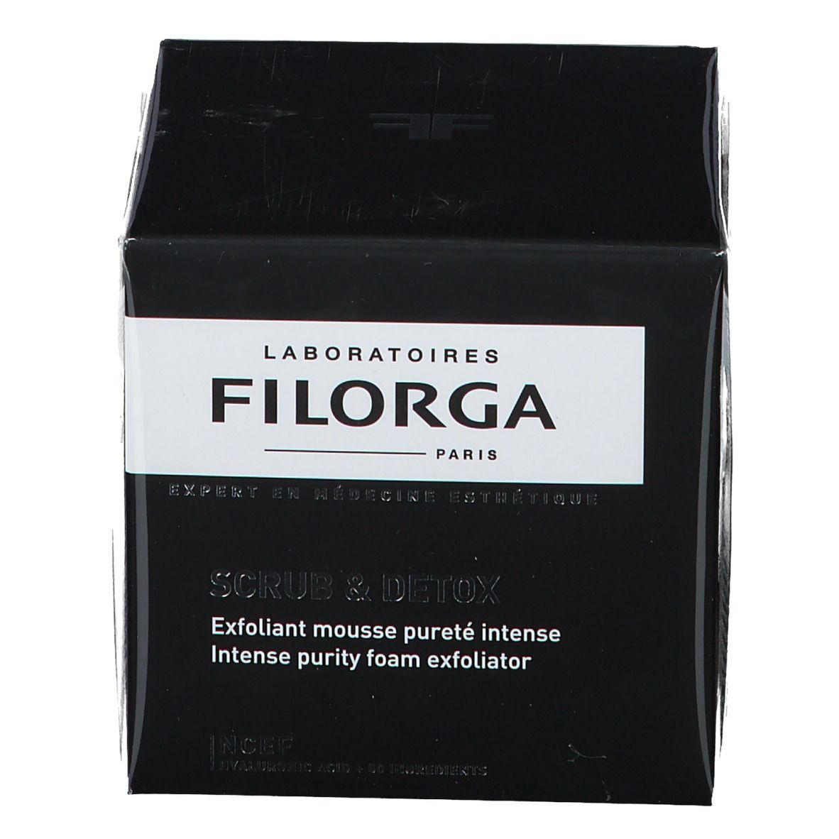 Boîte noire avec étiquette blanche. Inscription FILORGA SCRUB & DETOX. Texte: Exfoliant mousse pureté intense, Intense purity foam exfoliator.