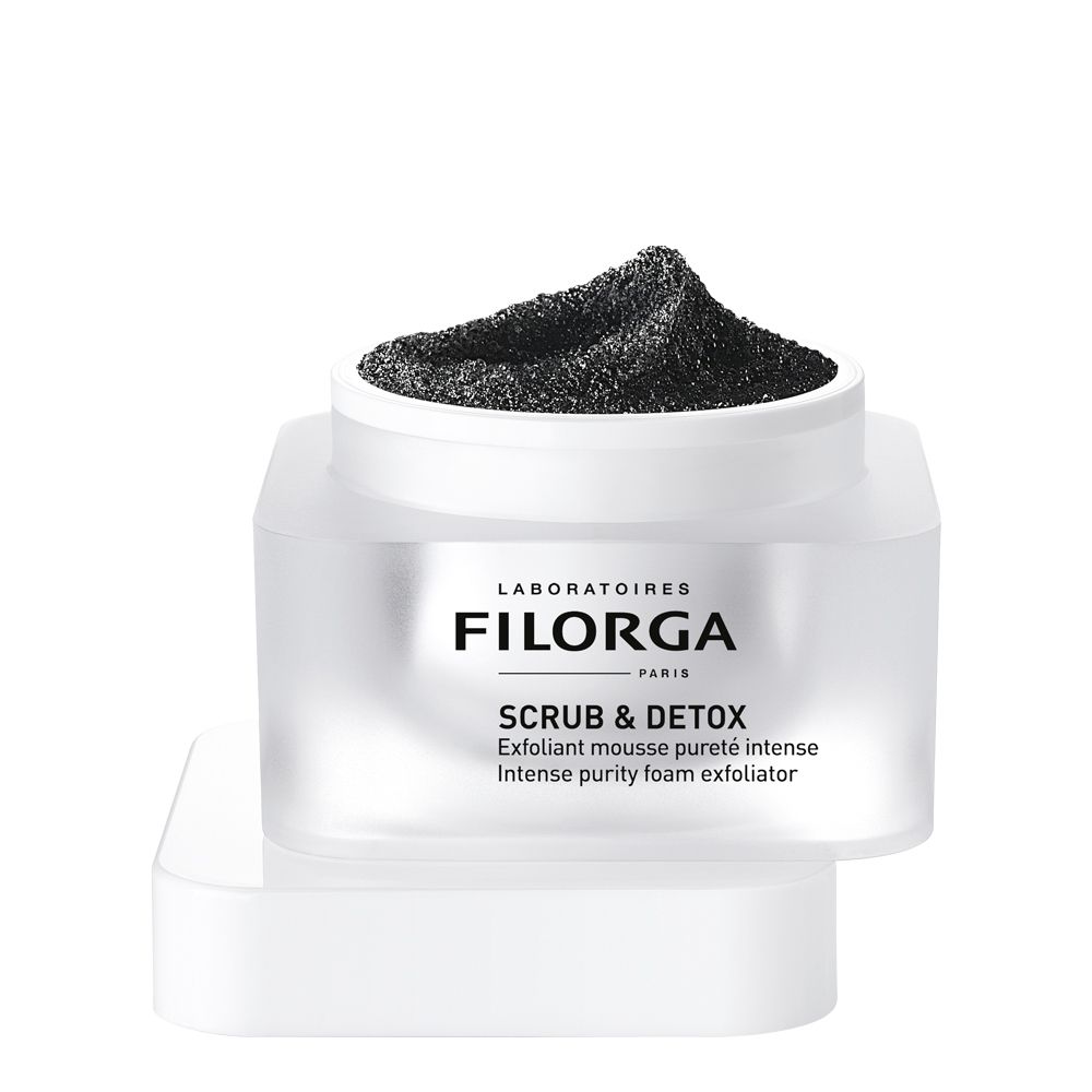 Pot blanc avec contenu noir et couvercle retiré. Inscription FILORGA SCRUB & DETOX. Texte: Exfoliant mousse pureté intense.