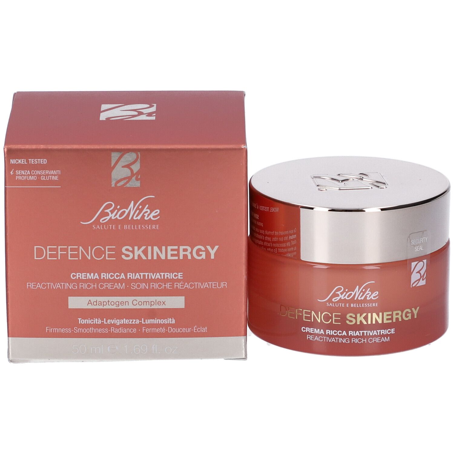 Vaso di crema e scatola. Scritta: Defence Skinergy, Crema Ricca Riattivatrice. Confezione rossa.