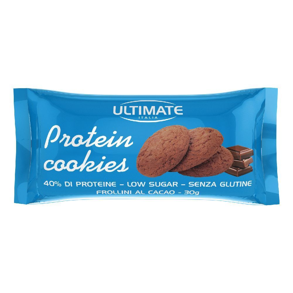 Confezione blu di Protein cookies. Scritta "ULTIMATE Protein cookies". Tre biscotti e cioccolato. Testo: 40% proteine, a basso contenuto di zuccheri, senza glutine.