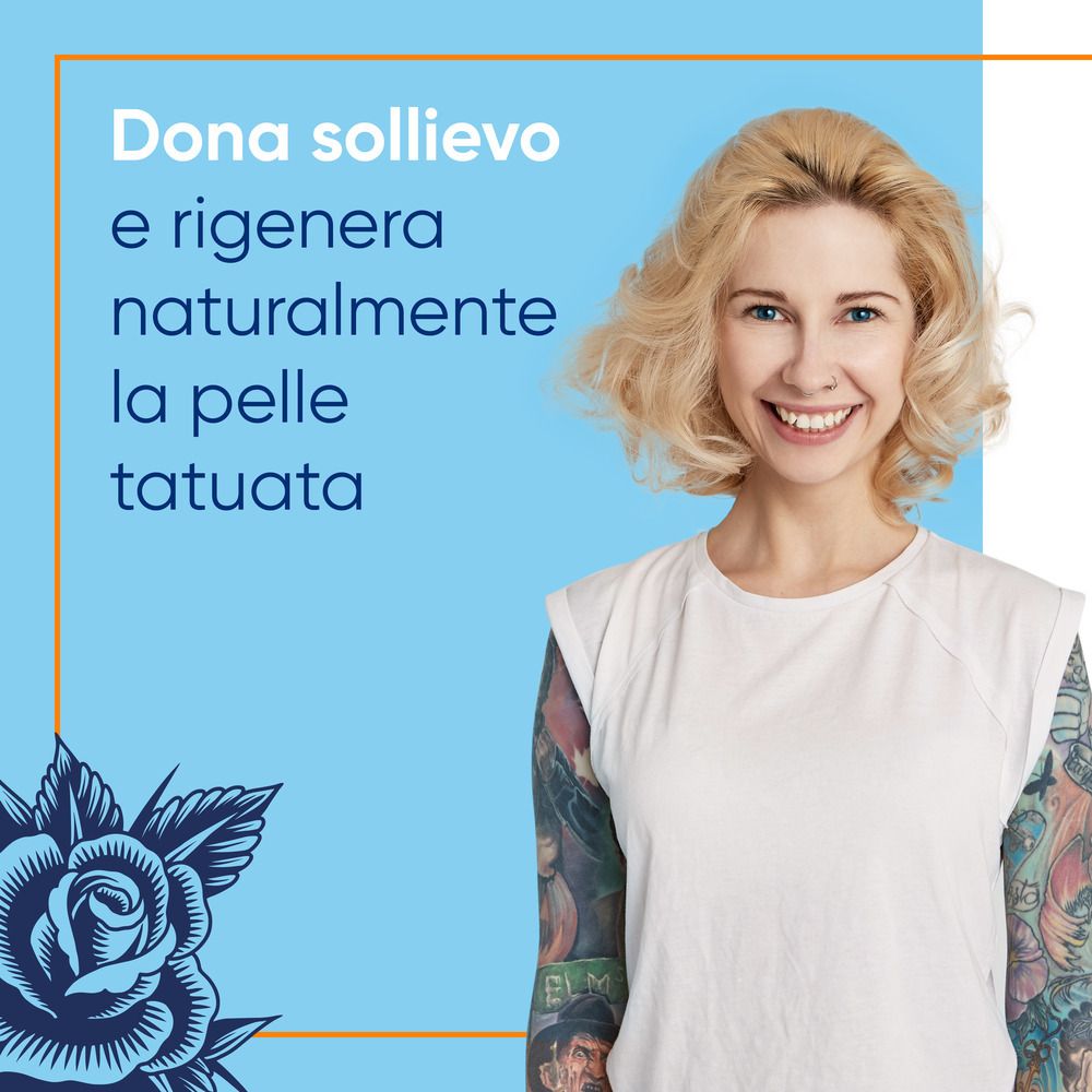 Frau mit Tattoo-Armen lächelt. Text: Lindert und regeneriert die tätowierte Haut. Blaue Rose-Illustration.