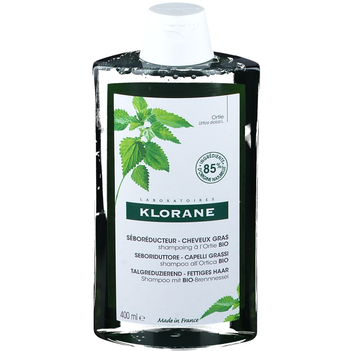 Grüne Shampoo-Flasche mit weißem Deckel. Aufschrift: KLORANE, SÉBORÉDUCTEUR, 85% natürliche Inhaltsstoffe. Brennnessel-Blätter.
