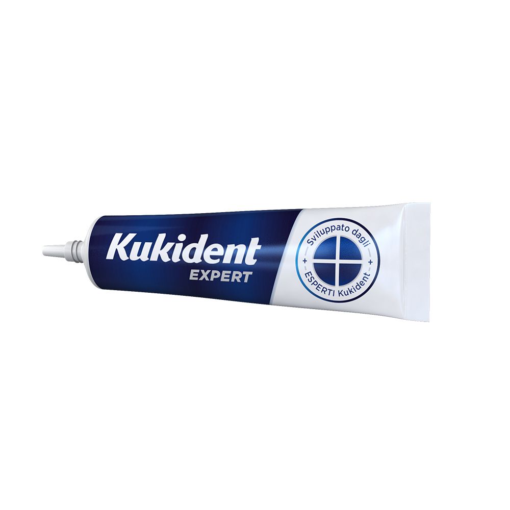 Tubo Kukident Expert. Tubo blu con testo bianco. Chiusura bianca. Nome del prodotto e logo visibili.
