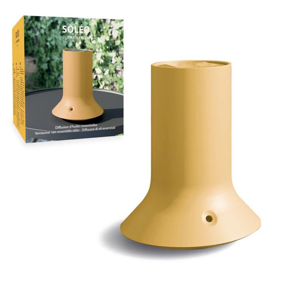 Diffusore giallo con base ampia e corpo cilindrico. Su tavolo nero, accanto alla confezione.