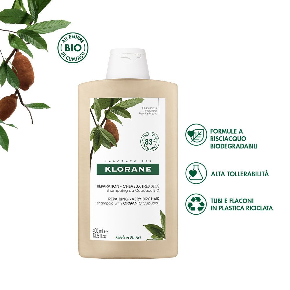 Flacone di shampoo beige con tappo bianco. Scritta KLORANE, testo e illustrazioni di foglie e frutti. Con icone.