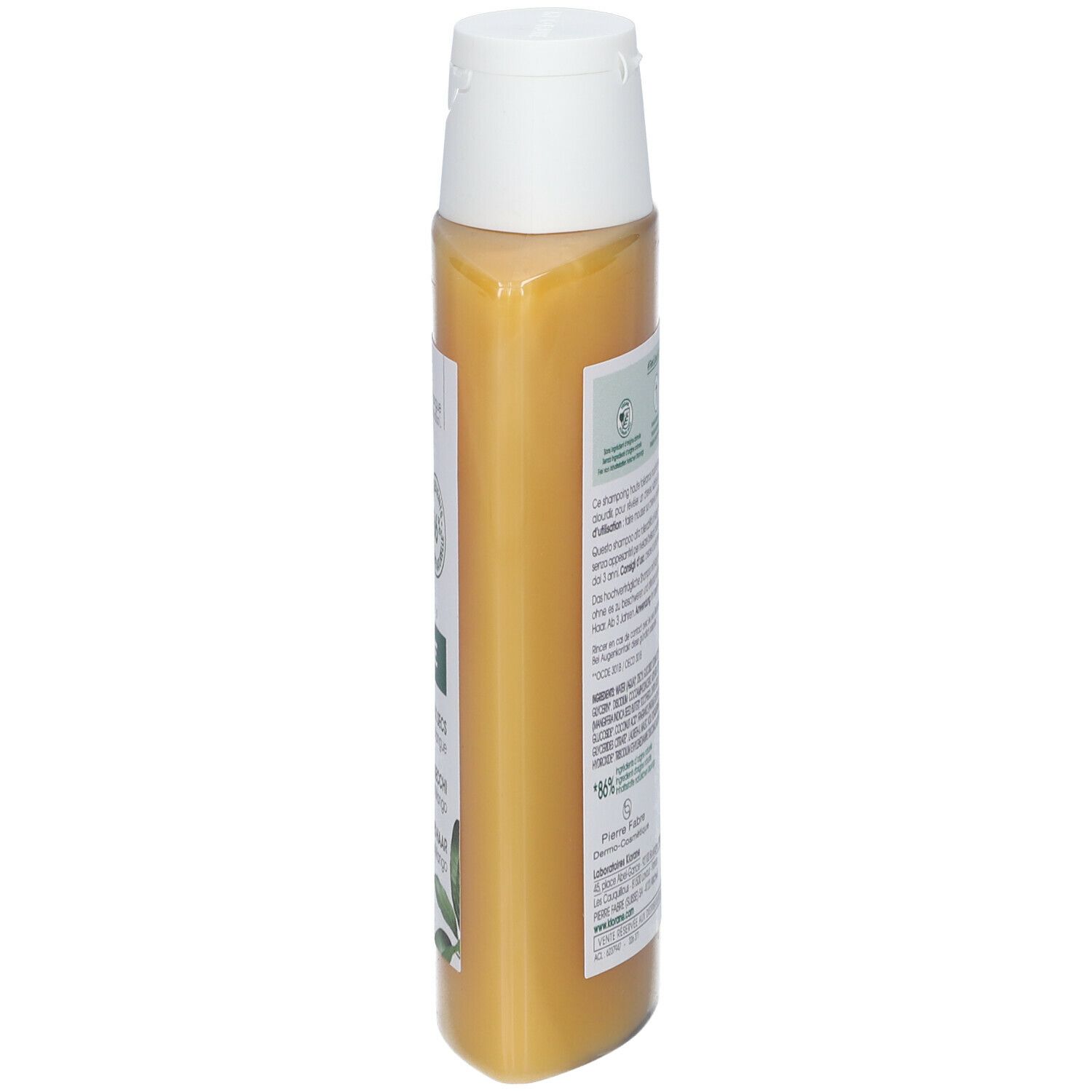 Vue latérale d'un flacon de shampooing jaune. Texte et illustration de mangue visibles.