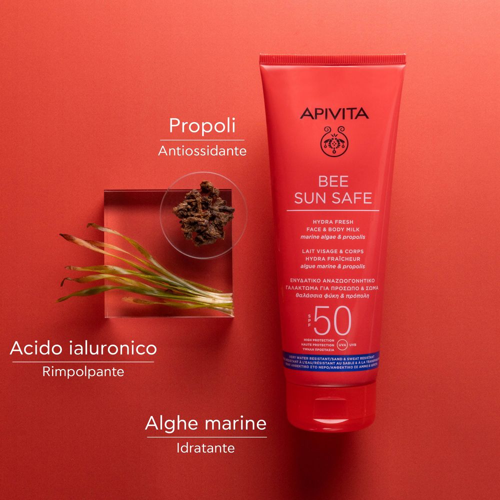 Tubo rosso APIVITA BEE SUN SAFE. Testo: Hydra Fresh Face & Body Milk SPF50. Ingredienti: Propoli, acido ialuronico, alghe.