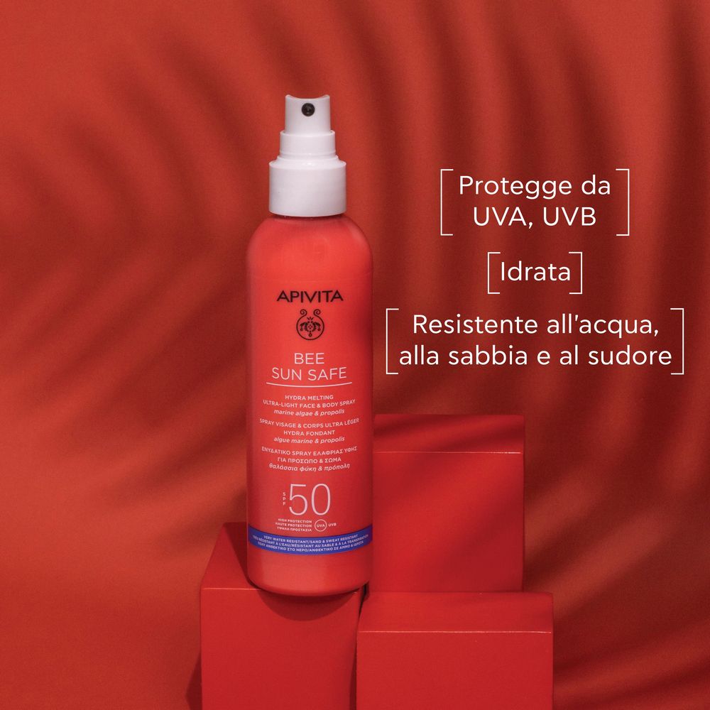Flacone spray rosso con erogatore bianco. Scritta: APIVITA BEE SUN SAFE, SPF 50. Su sfondo rosso.