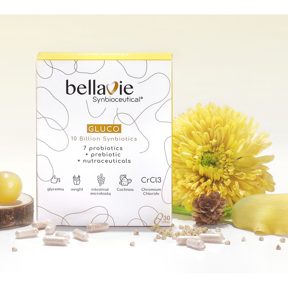 Doosje BellaVie GLUCO capsules. Opschrift: 10 miljard synbiotica, 7 probiotica, prebiotica, nutraceuticals. Met gele bloem en capsules.