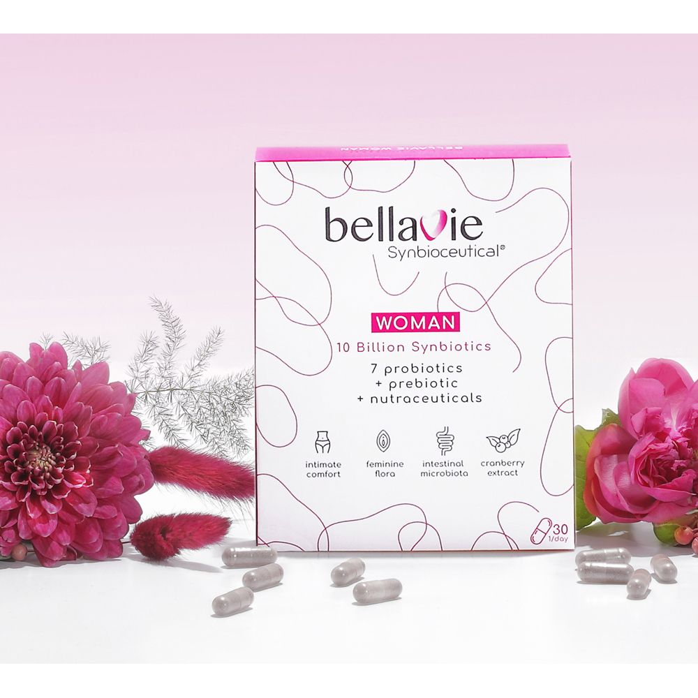 Roze doos "BellaVie WOMAN" met capsules en bloemen. Bevat 10 miljard synbiotica, 7 probiotica, prebiotica en nutraceuticals. 30 capsules.