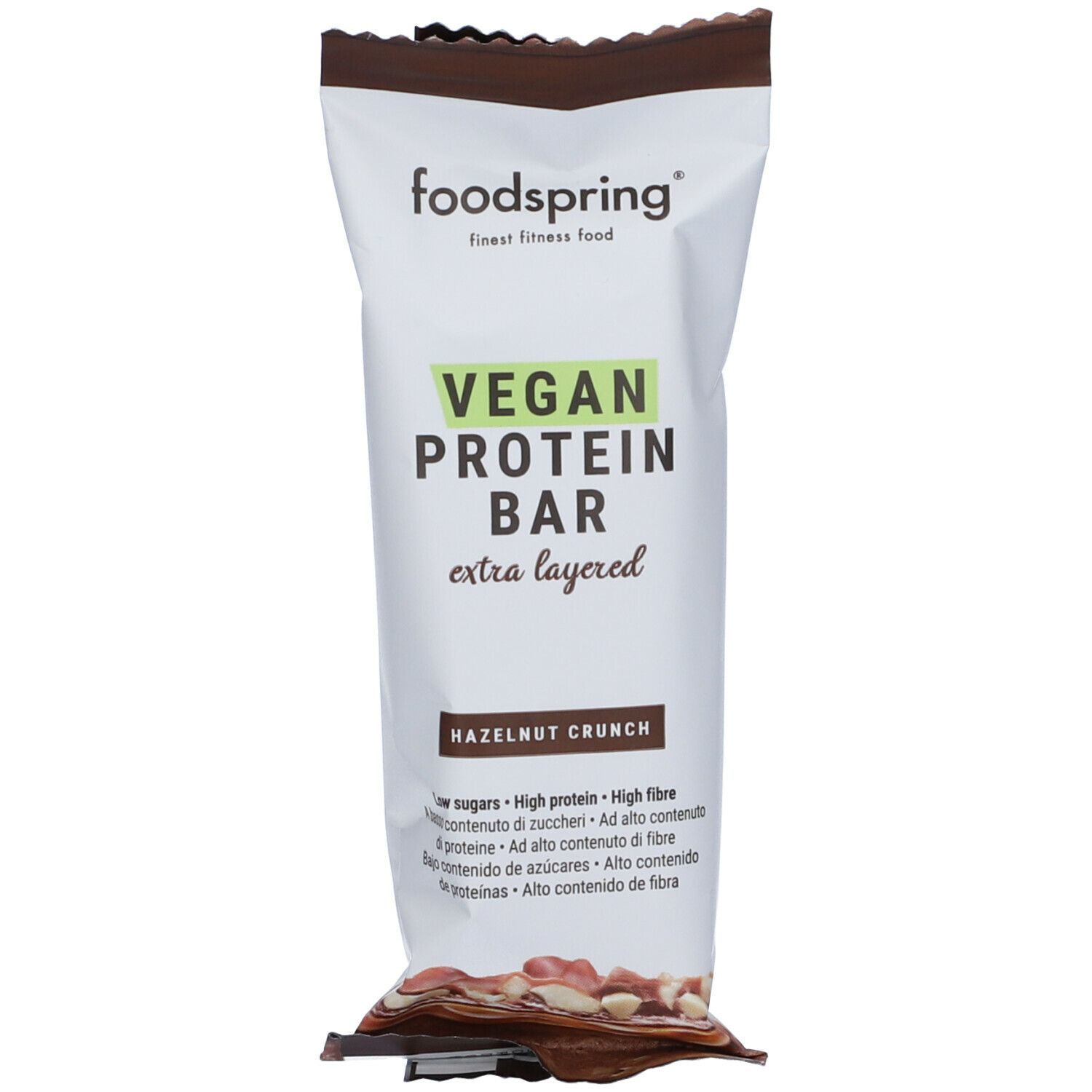Barretta proteica vegana Foodspring nella confezione. Scritta: Vegan Protein Bar, Hazelnut Crunch. Testo: low sugars, high protein, high fibre.