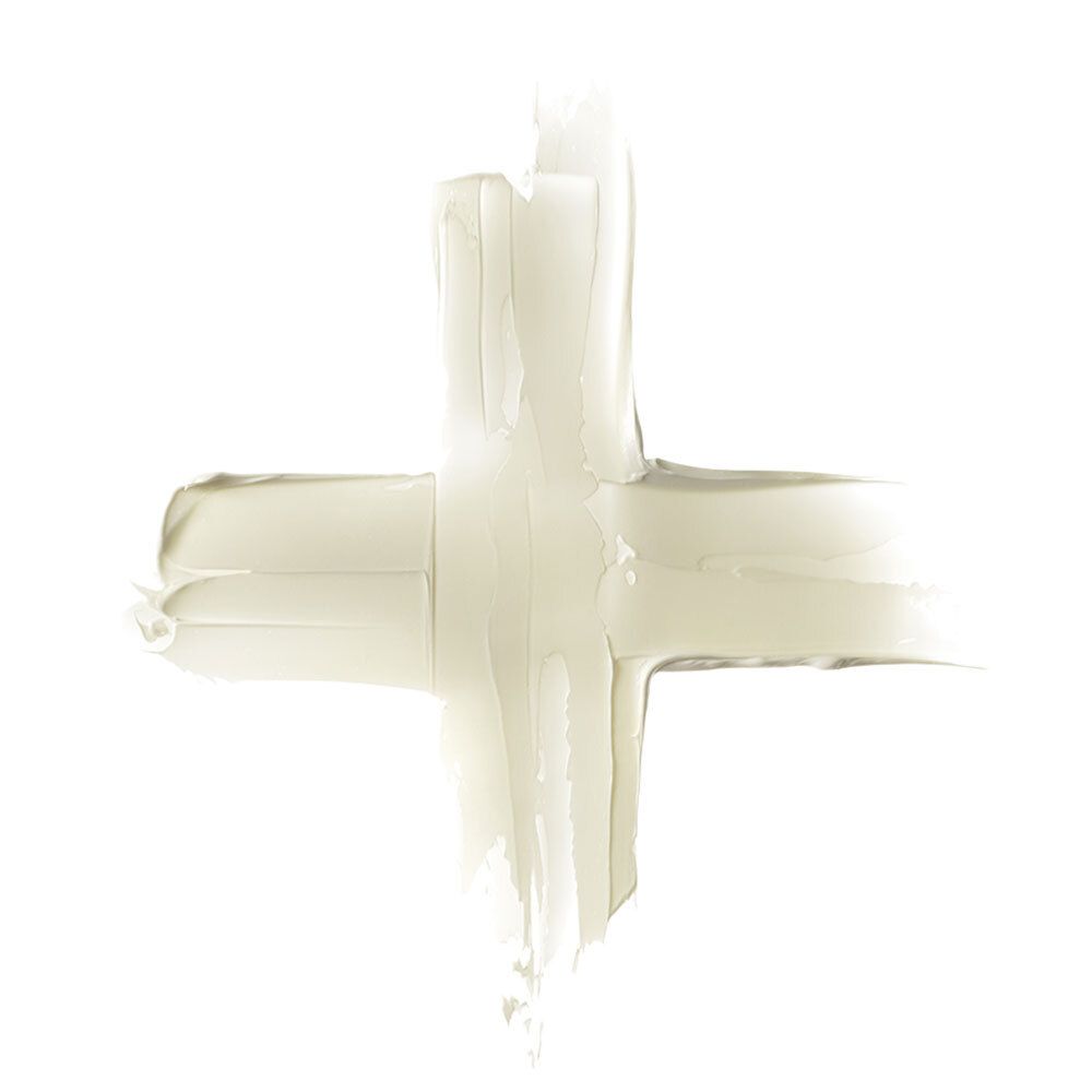 Sfondo bianco con sostanza color crema a forma di croce. Consistenza della crema.