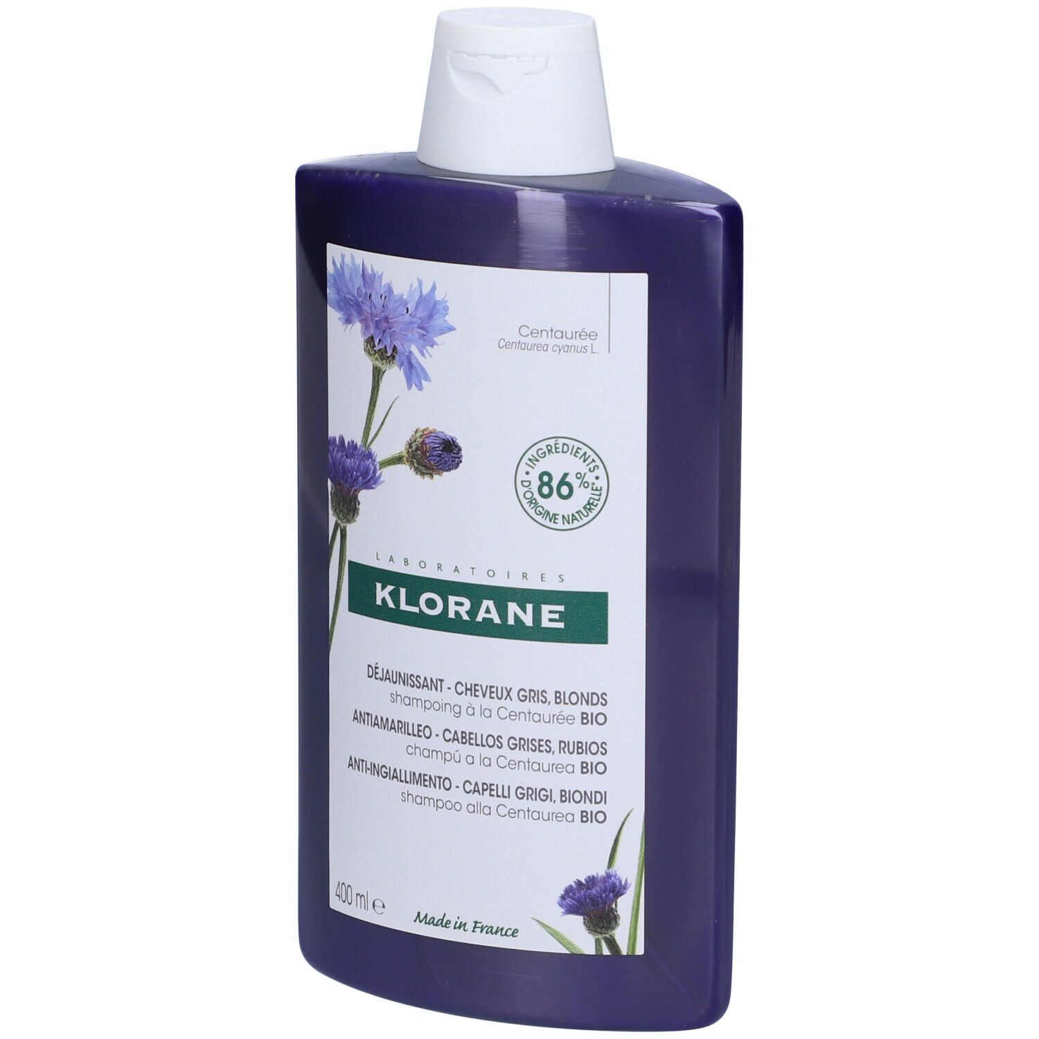Flacone di shampoo blu con tappo bianco. Etichetta con nome del prodotto, illustrazione di fiordalisi e 86% di ingredienti naturali.