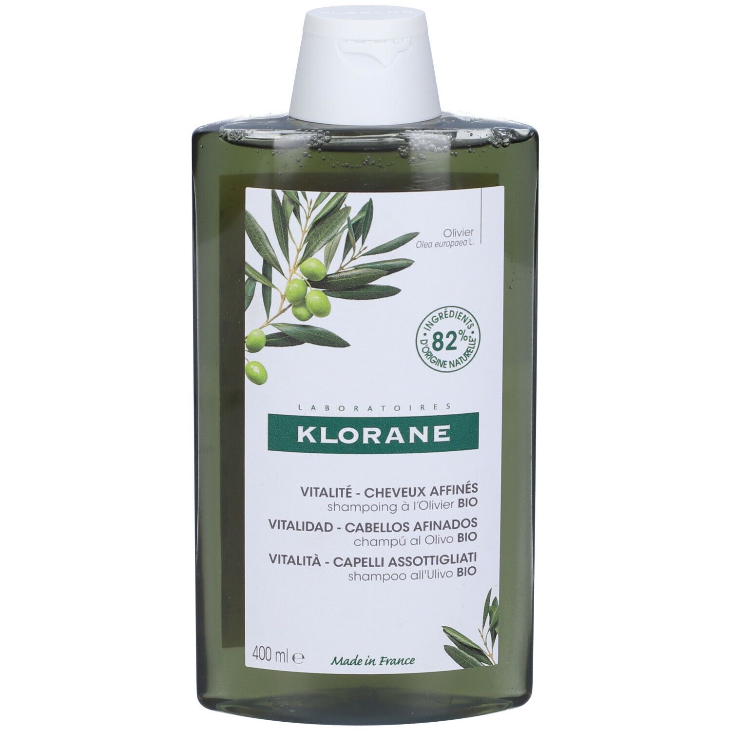 Flacone di shampoo verde con illustrazione di ramo d'ulivo e testo. Contiene l'82% di ingredienti di origine naturale.
