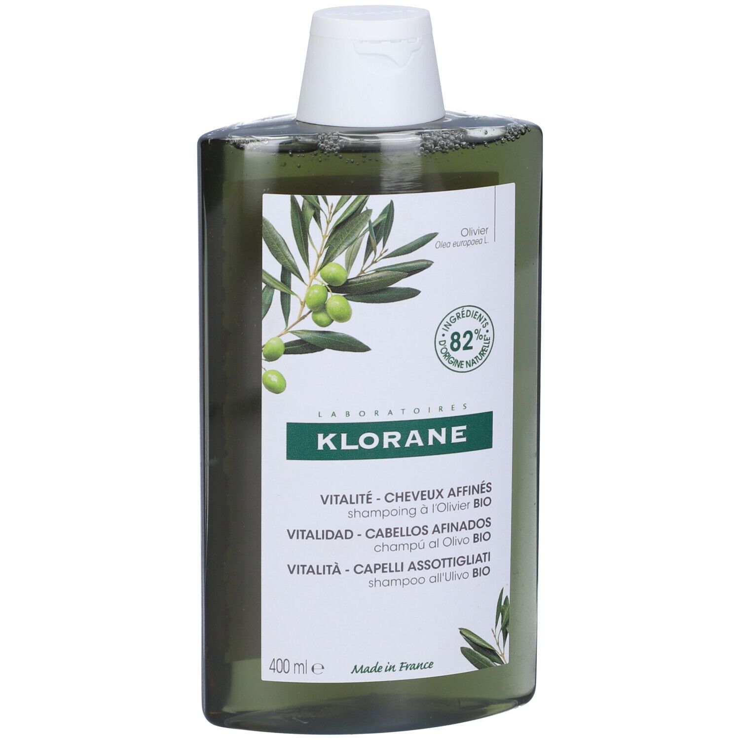 Flacone di shampoo verde con illustrazione di ramo d'ulivo e testo. Contiene l'82% di ingredienti di origine naturale.