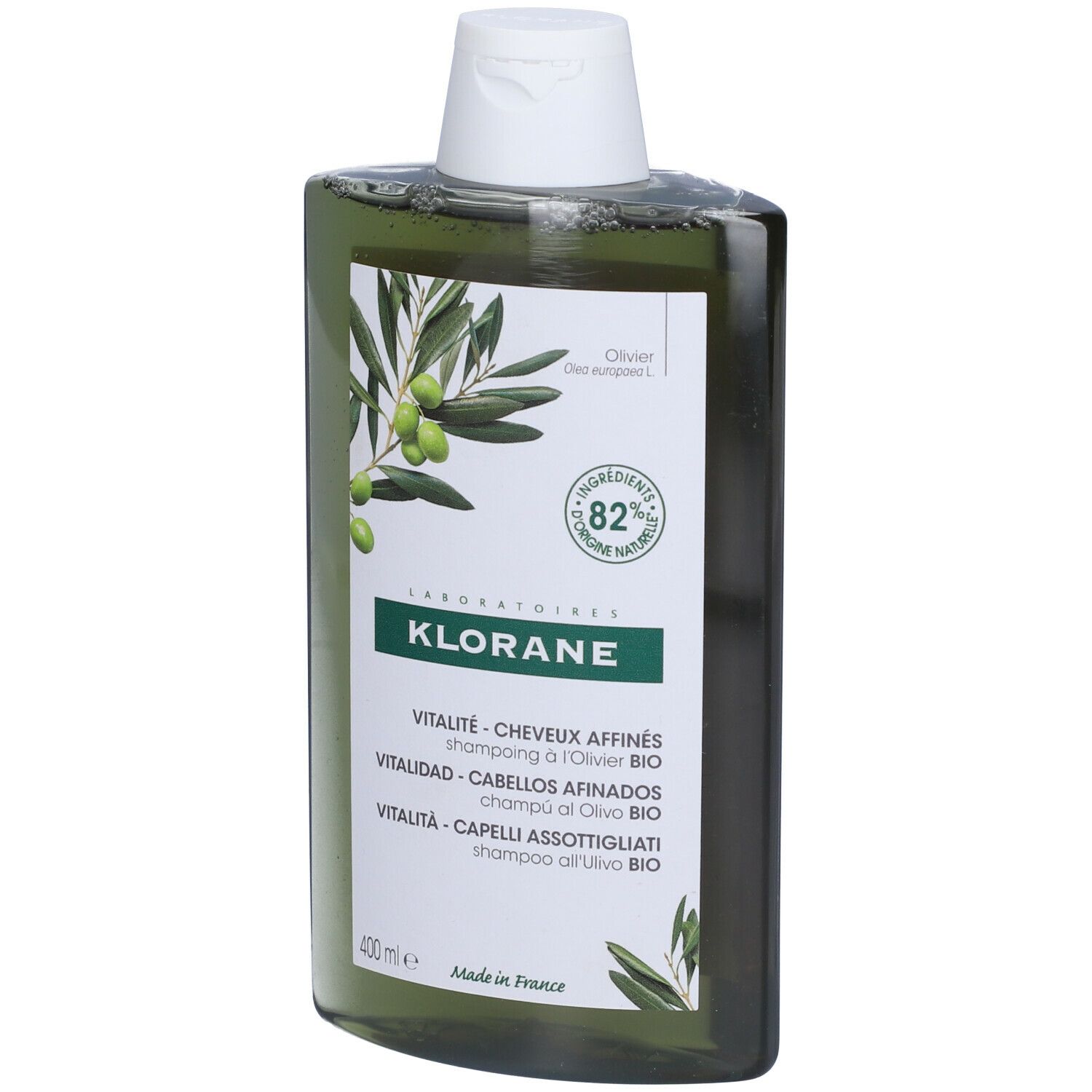 Flacone di shampoo verde con illustrazione di ramo d'ulivo e testo. Contiene l'82% di ingredienti di origine naturale.