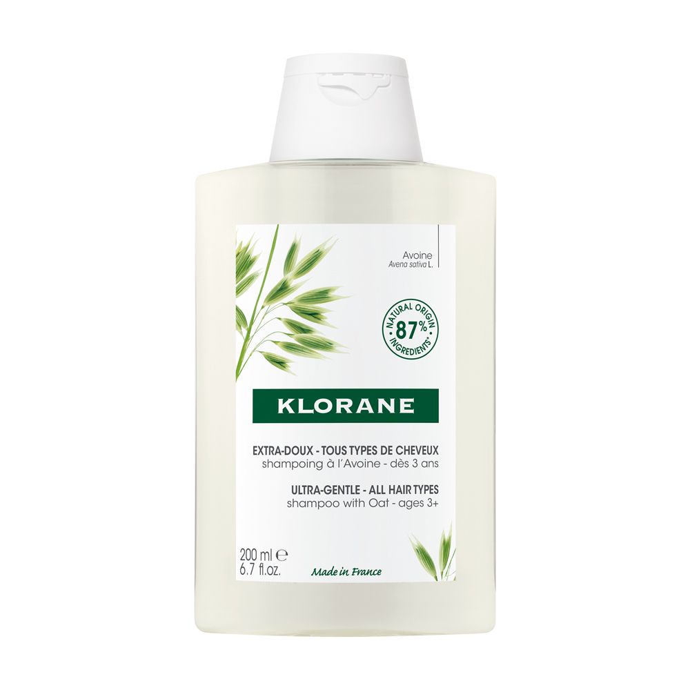 Flacone di shampoo bianco con etichetta verde. Testo: Klorane, Extra-Doux, 87% ingredienti naturali. Made in France.