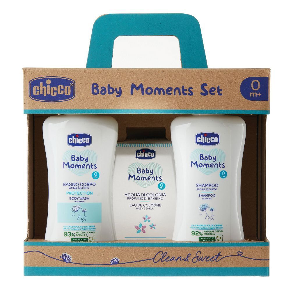 Set di prodotti per l'infanzia in confezione di cartone con manico. Contiene flaconi e sapone. Scritta: Baby Moments, 0m+.