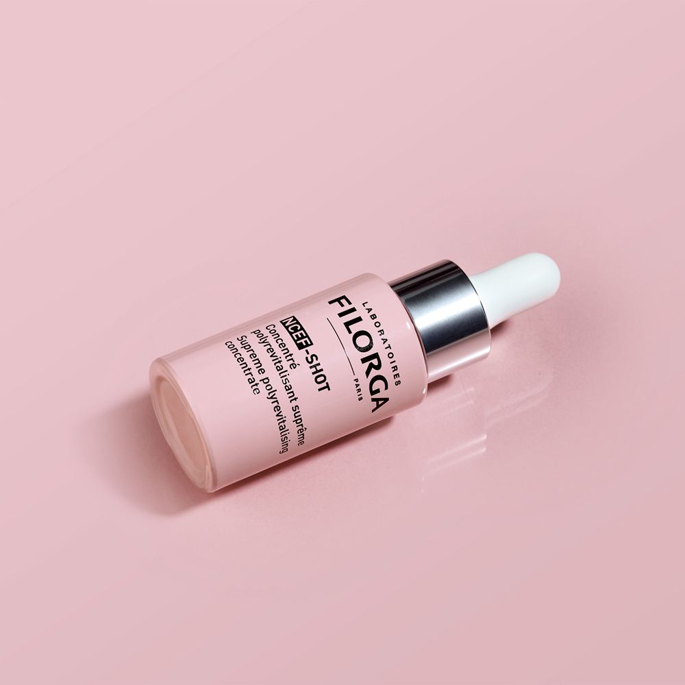 Flacone sdraiato. Testo: FILORGA, NCEF-SHOT. Flacone rosa. Sfondo: rosa.