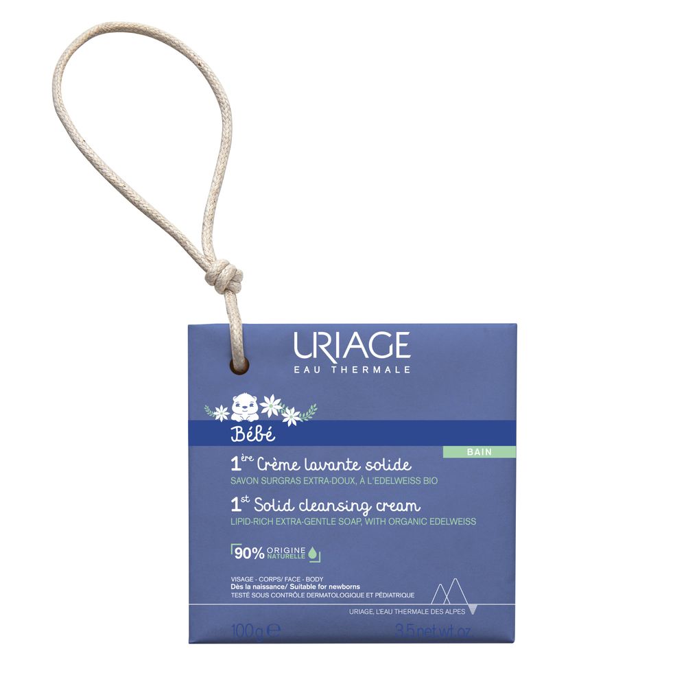Confezione blu con informazioni sul prodotto. Scritta: URIAGE Bébé, 1a Crème lavante solide. Con cordino per appendere.