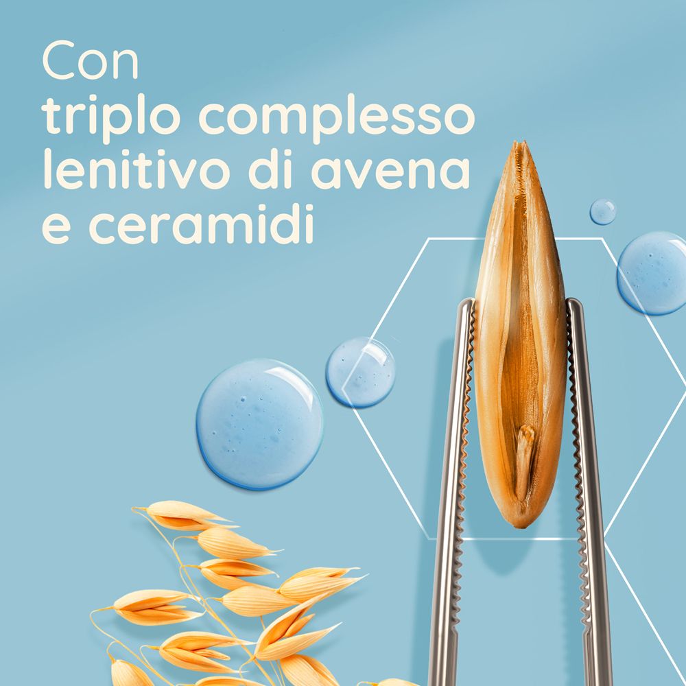 Primo piano di chicchi d'avena e pinzette. Testo: Con triplo complesso lenitivo di avena e ceramidi.